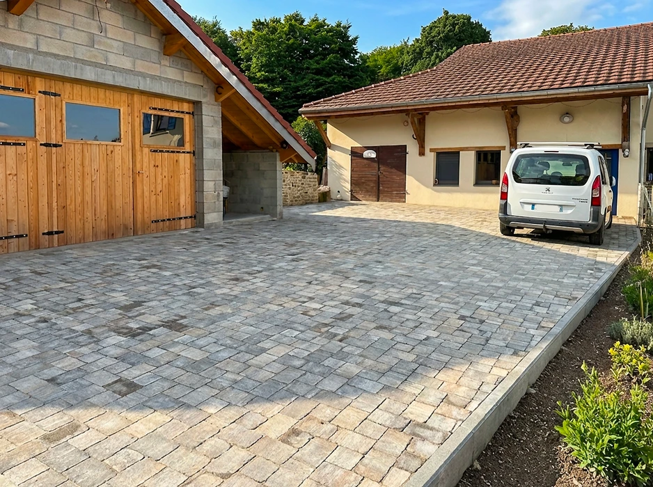 Vaste allée de garage extérieure pavée en pavés autobloquants en béton vieilli, ton gris mélangé